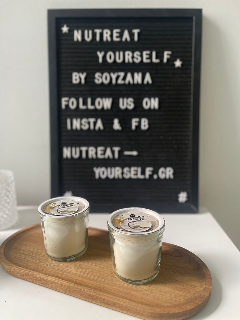a set of candles on a wooden board in front of a sign